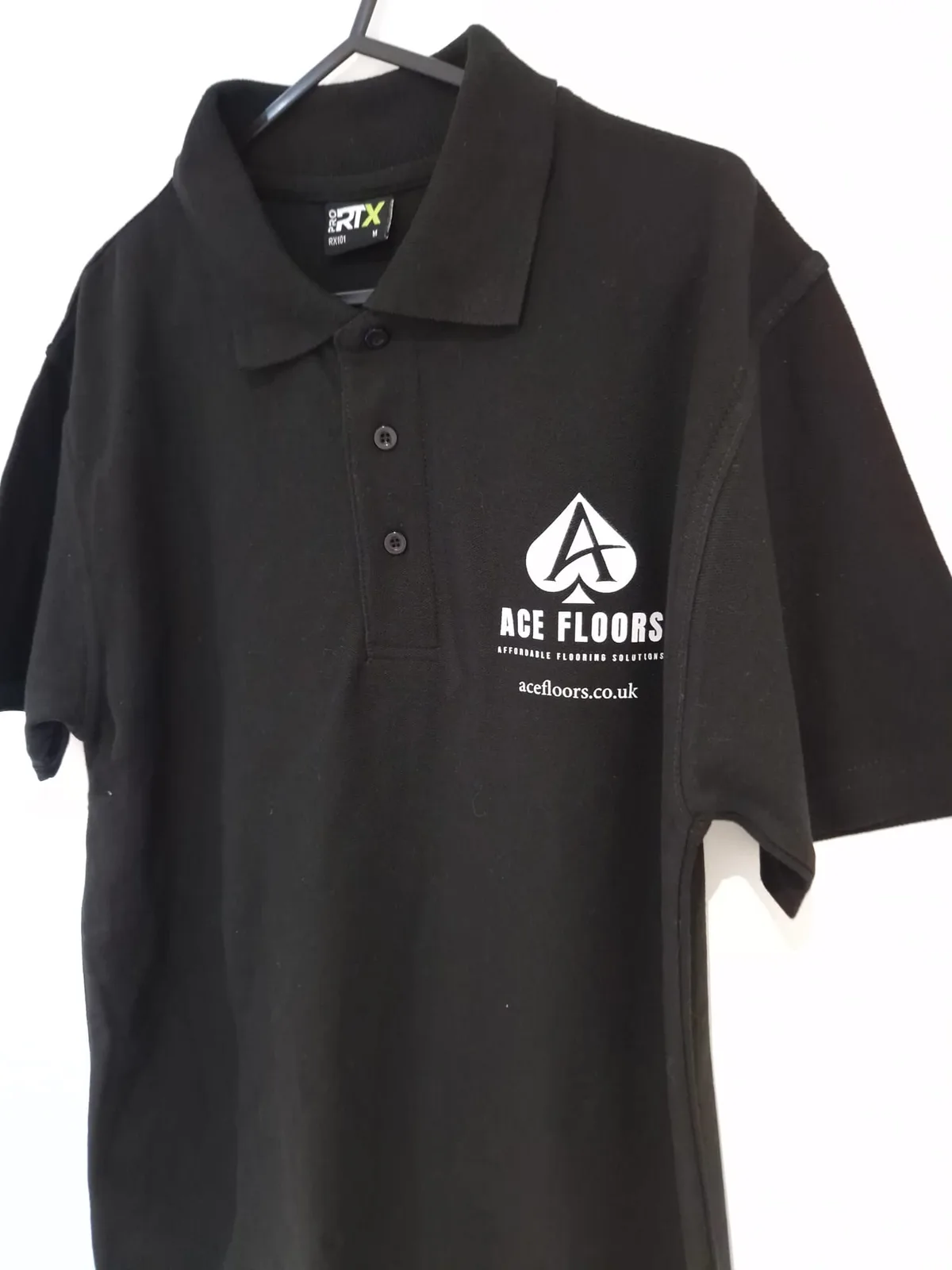 Black polo shirt with Ace Floors chest branding