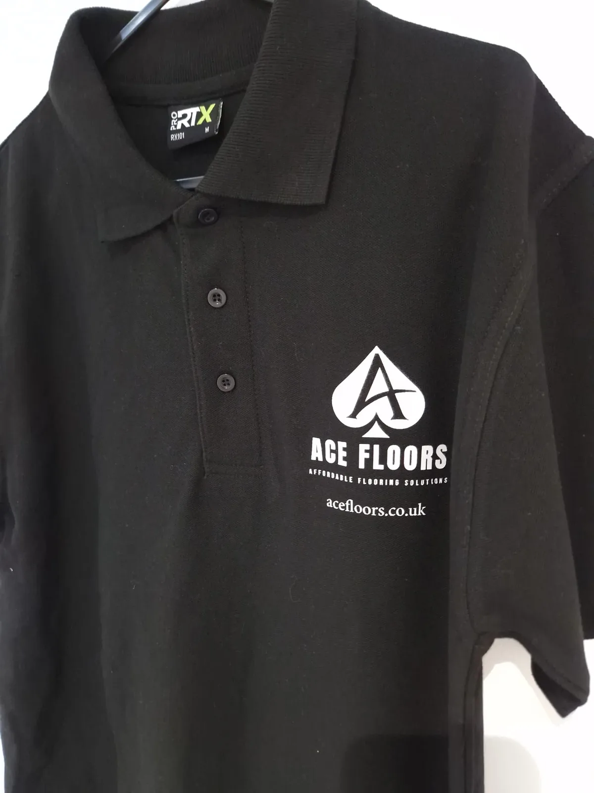 Black polo shirt with Ace Floors chest branding