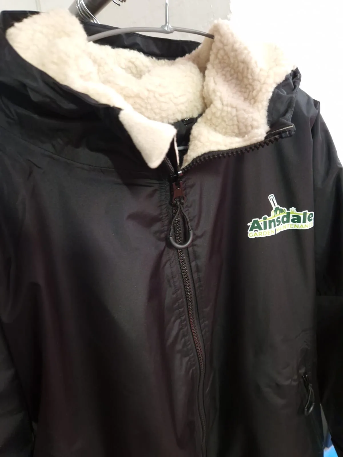Black fleece-lined jacket with Ainsdale chest logo