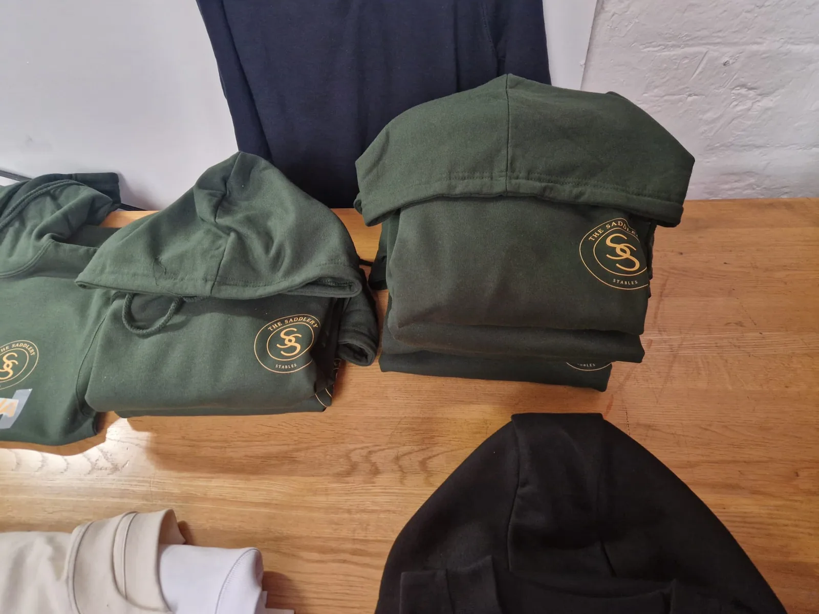 Assorted branded t-shirts and folded clothing on the worktable