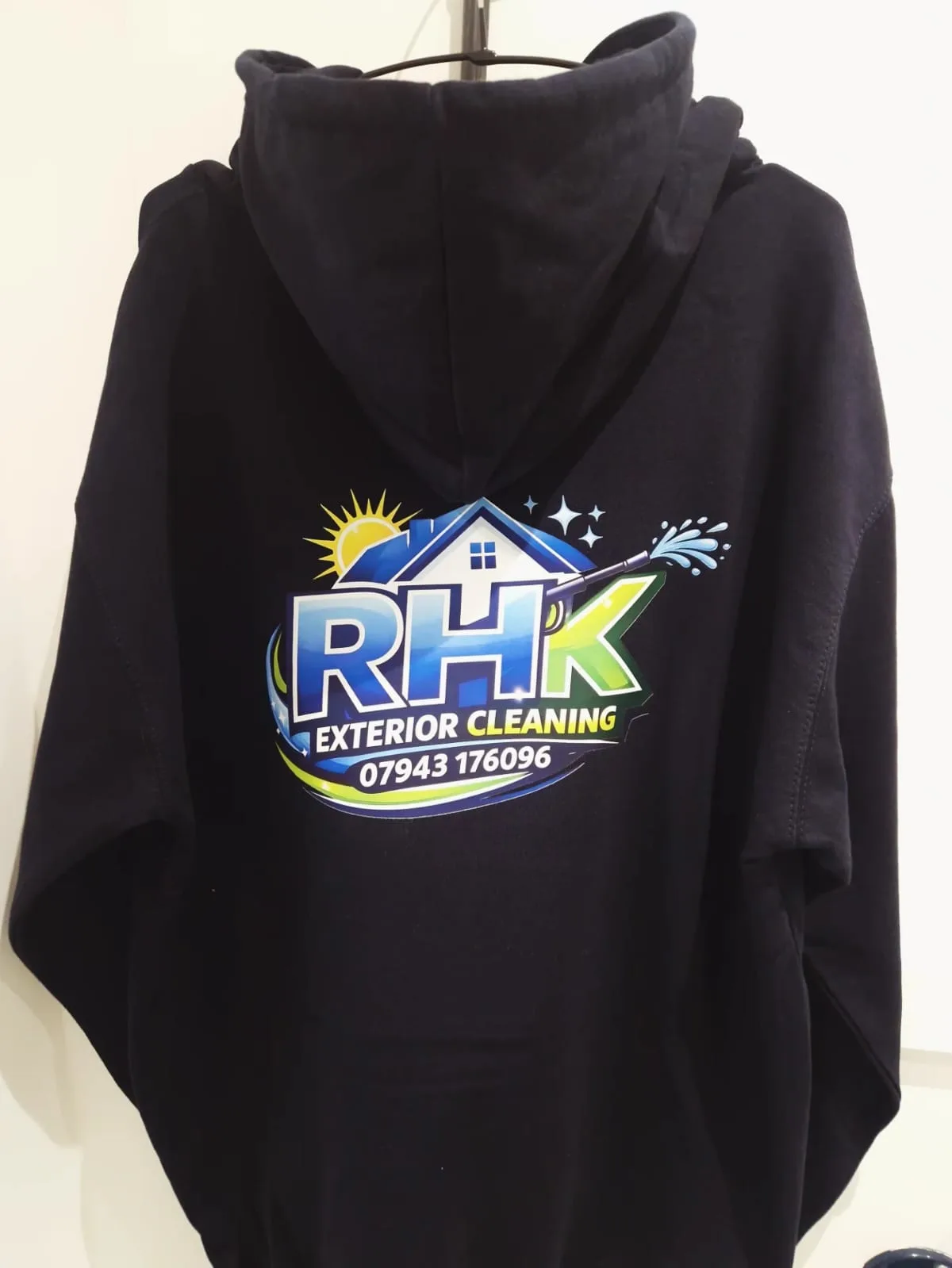 Black hoodie with RHK Exterior Cleaning back logo and telephone number