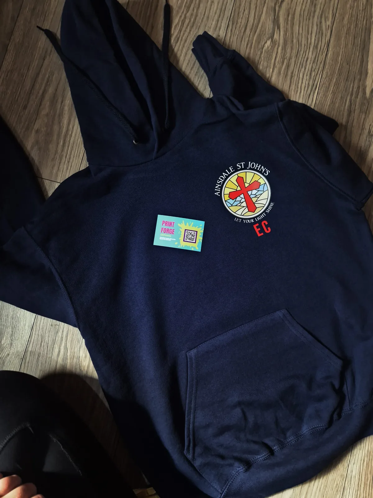 Navy hoodie with colourful circular school chest badge