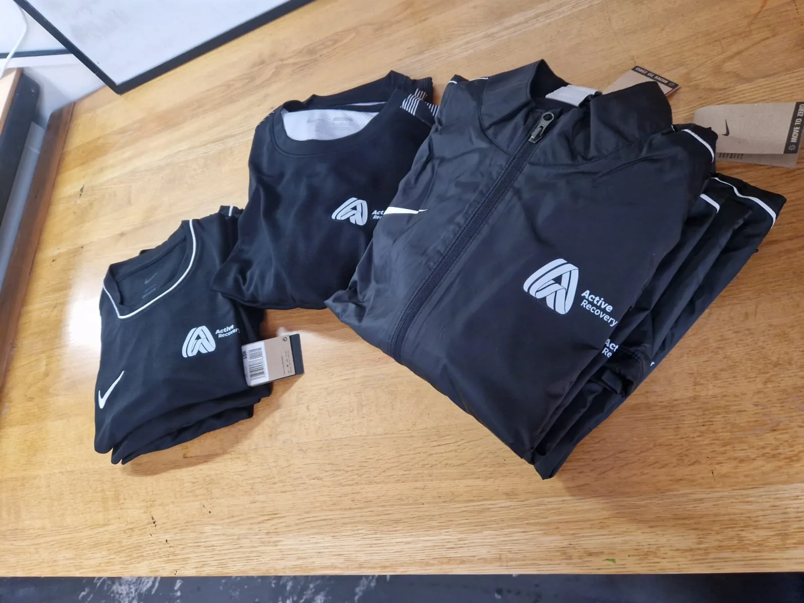 Folded navy Active Lancashire branded training tops and polos
