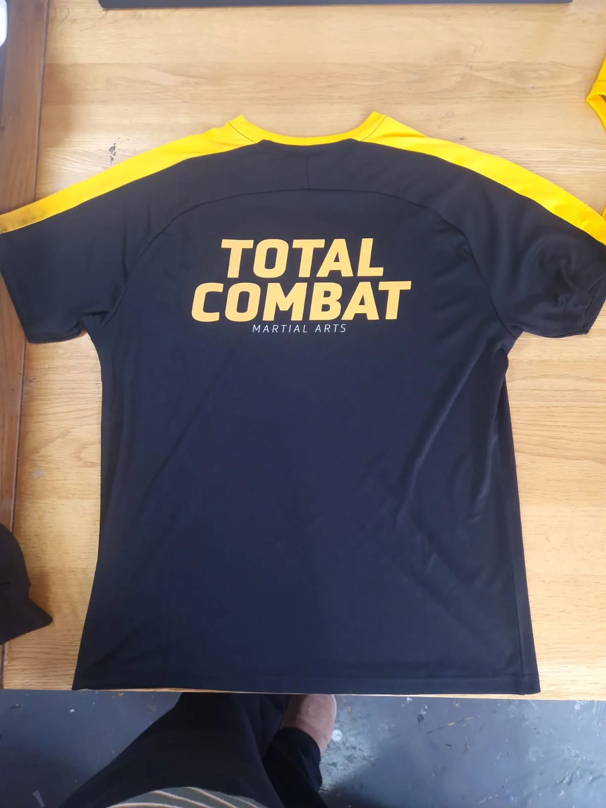Black Total Combat training top with yellow shoulder panels and back print