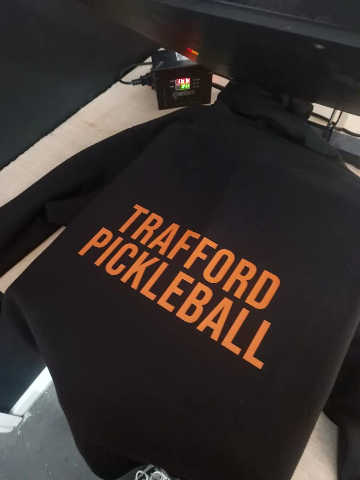 Black top with orange Trafford Pickleball back print
